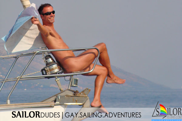 Nude guy sitting on sailing yacht bow in Greece