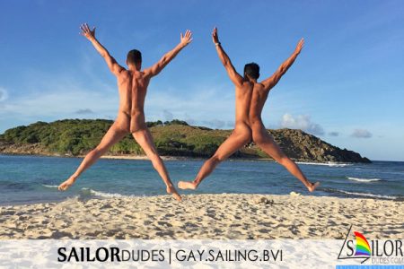 Two nude gay guys jumping on beach in BVI