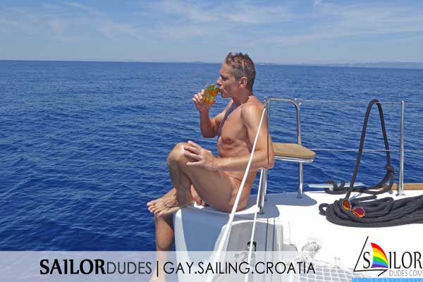 Gay naked guy drinking beer on sailing yacht in Croatia